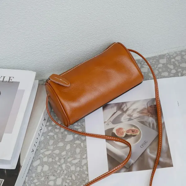 A tan leather barrel bag on a magazine