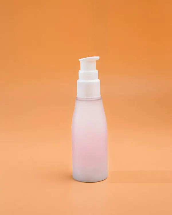 A white pump bottle on an orange background