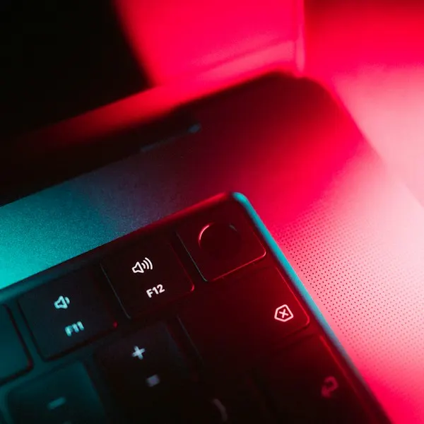 Close-up of a backlit keyboard in red and teal light