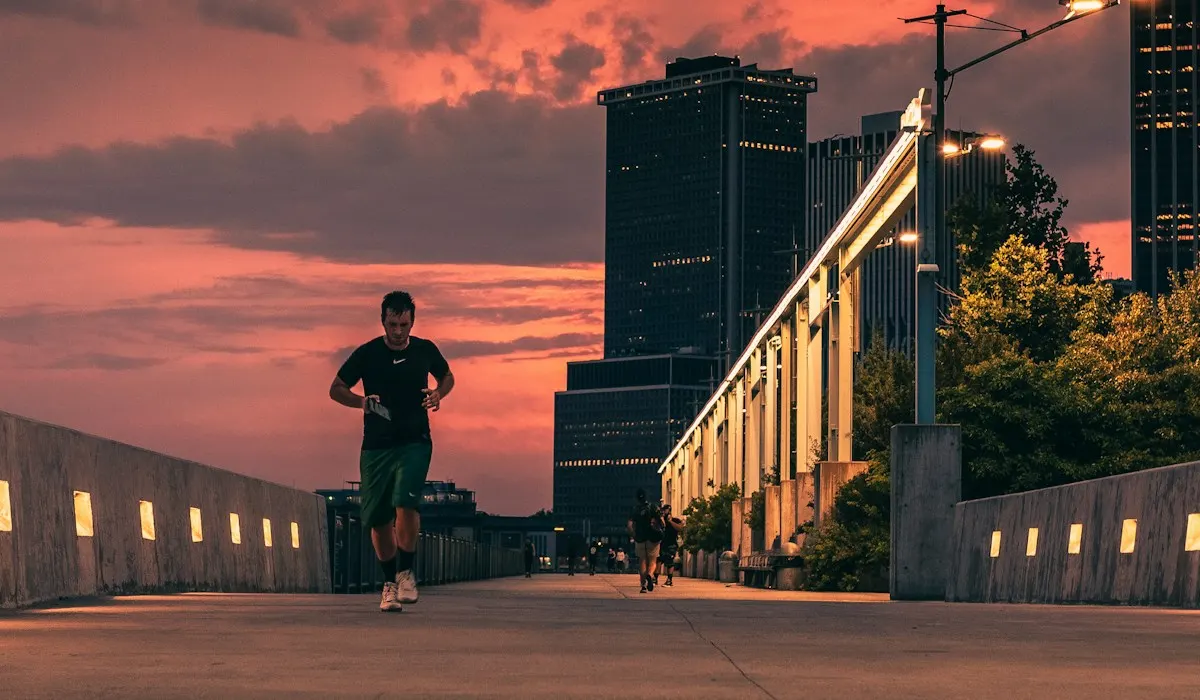 A runner on a city bridge at sunset